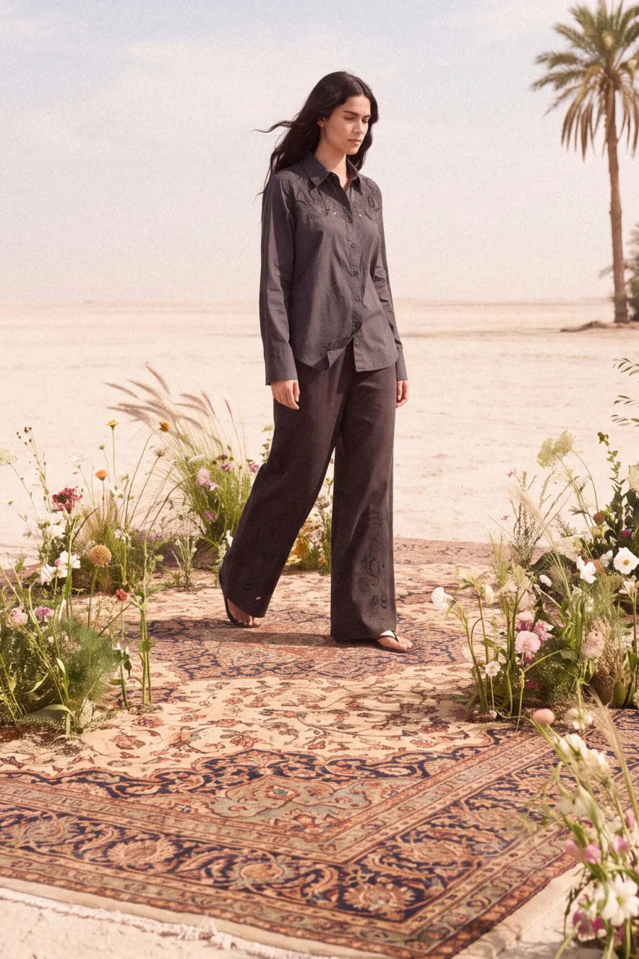 KINSHIP – grey shirt and trouser set on a woven rug